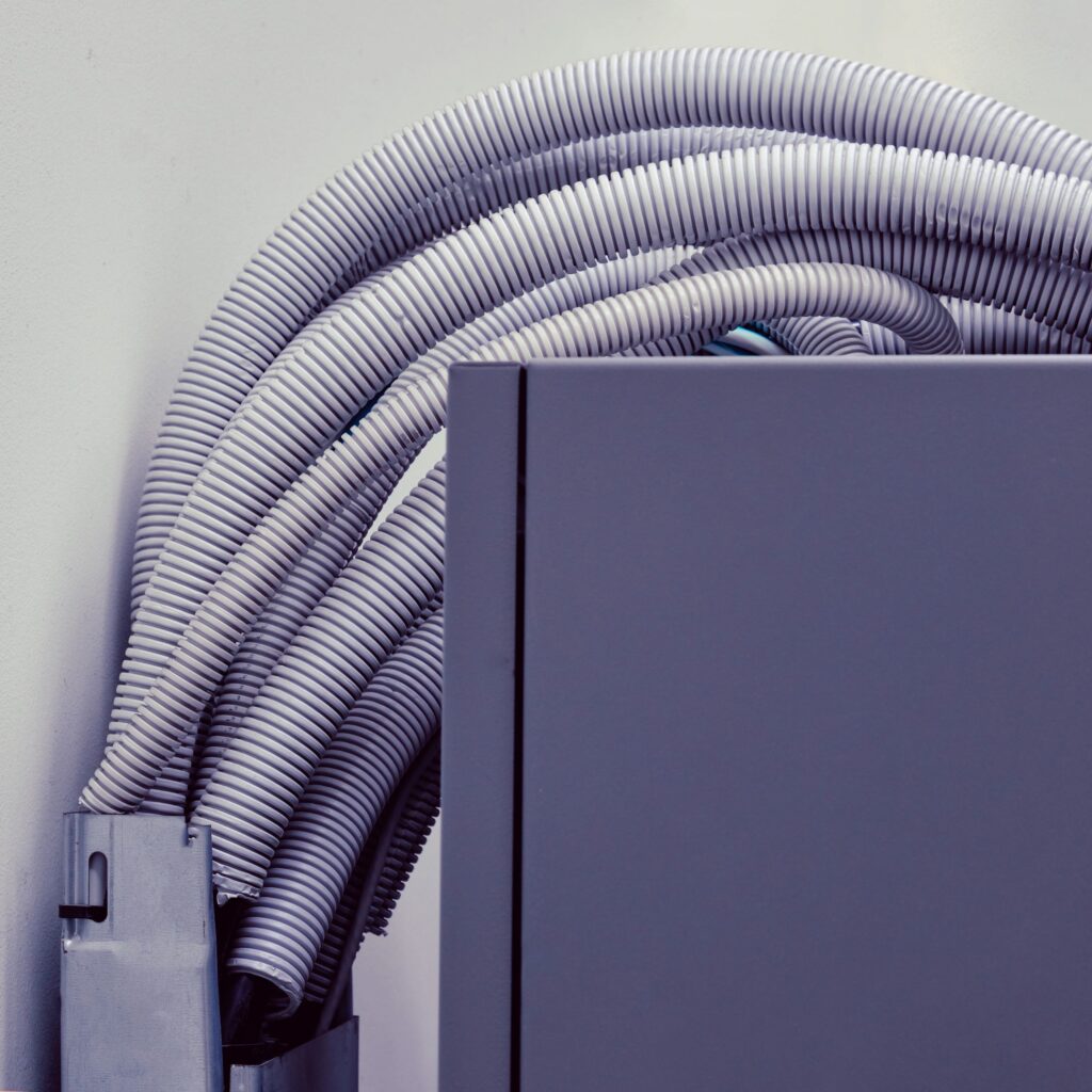 Electric cables and wires in white plastic corrugation, close up