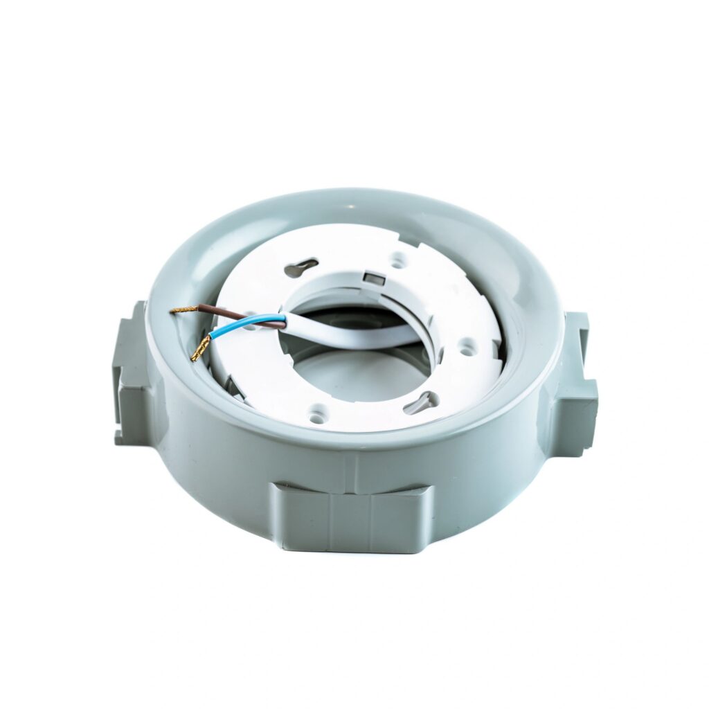 Round plastic ceiling electrical box with wires used for mounting lighting fixtures, displayed in a stretch ceiling and lighting equipment store.
