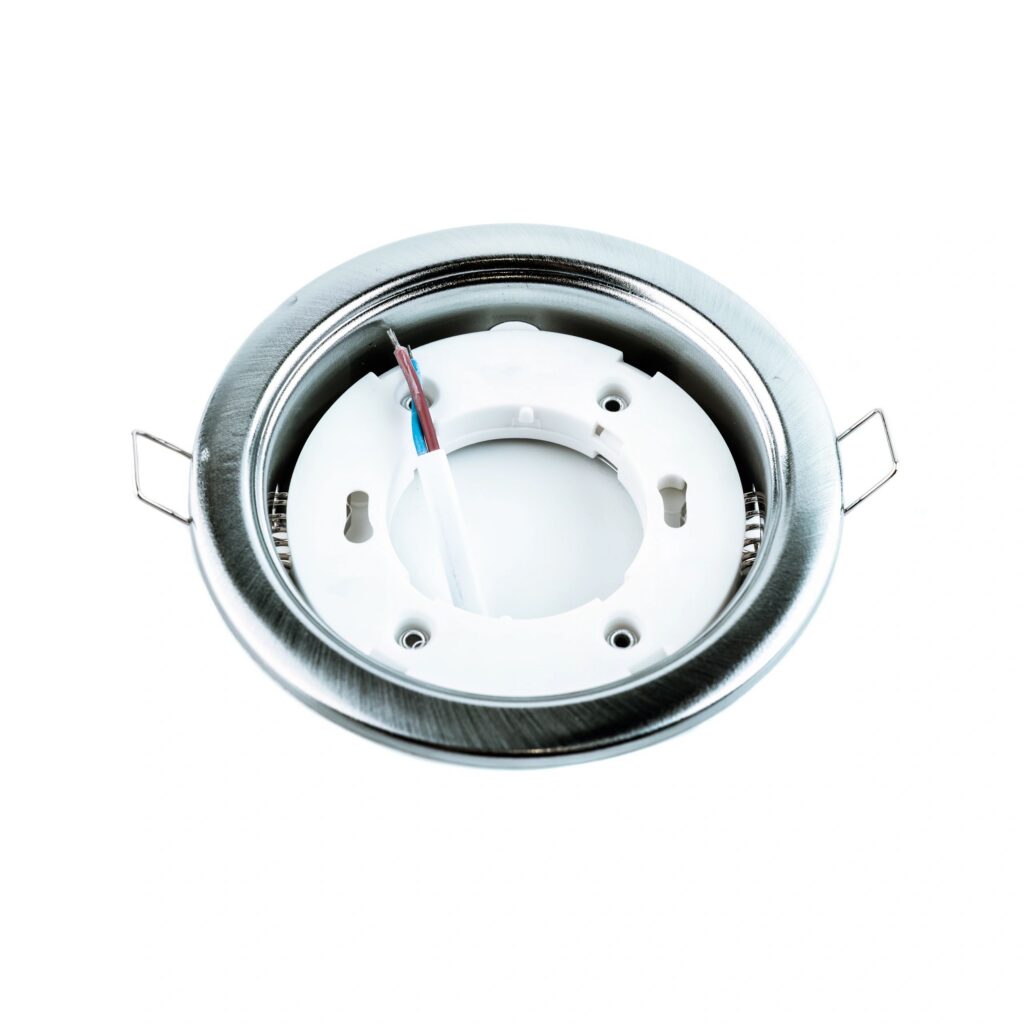 Round dark gray metal recessed ceiling light fixture frame for spotlights, used for mounting lamps in a stretch ceiling and lighting equipment store.
