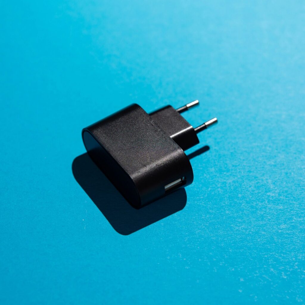 Black USB wall charger with EU plug on blue background